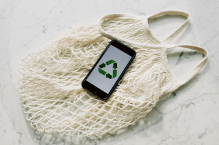 Recycle Symbol phone lying on white mesh bag 320 x213